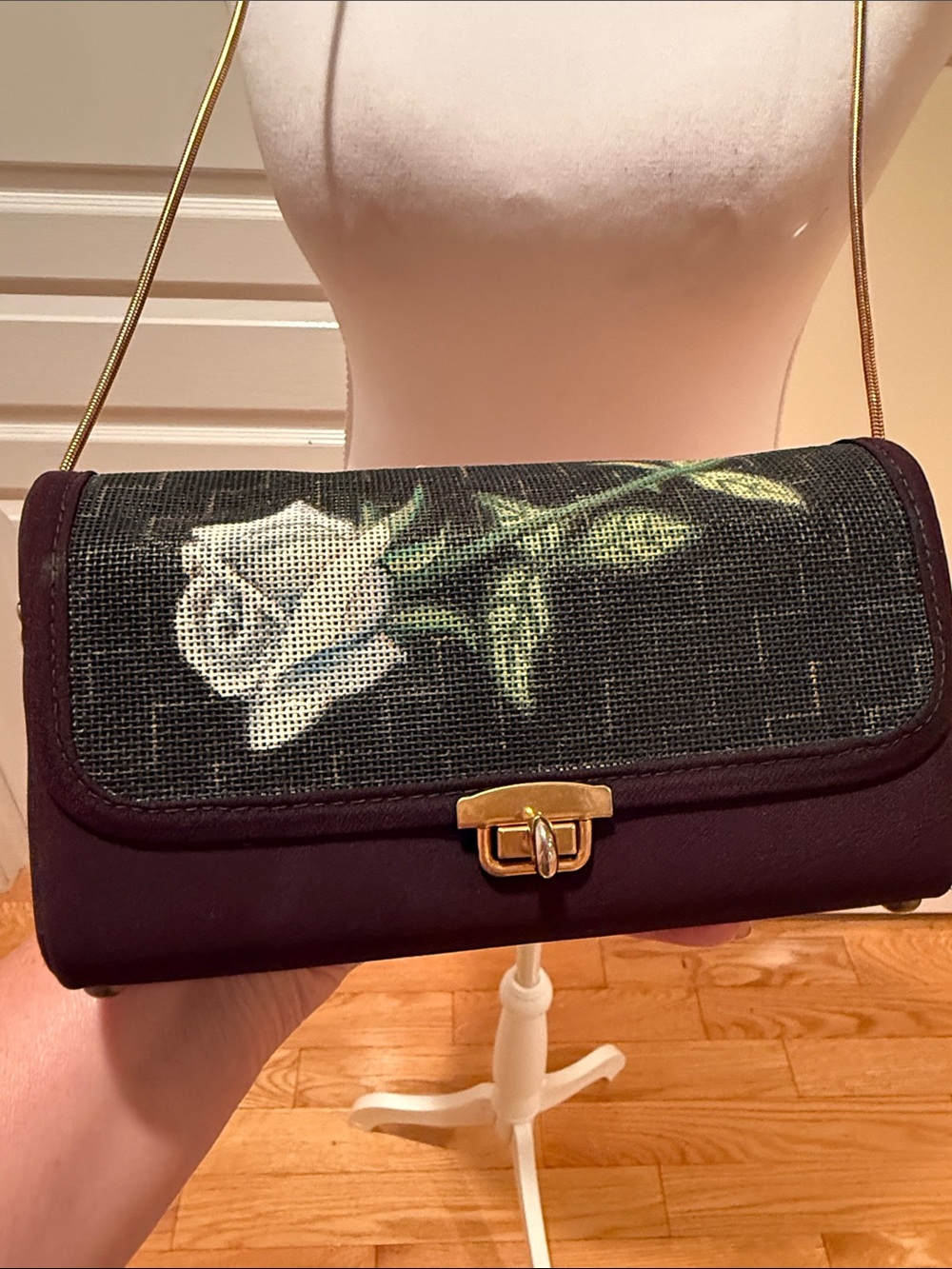 Vintage-Inspired Black Crossbody Bag with White Rose Detail and gold chain.